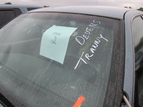 2001 Ford Crown Victoria - A car's windshield shows a paper tag and handwritten notes, with another vehicle visible outside.