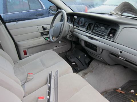 2001 Ford Crown Victoria - The interior of a 2001 Ford Crown Victoria, its dashboard, steering wheel, and front seats.