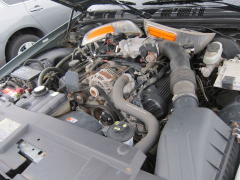 2001 Ford Crown Victoria - The engine bay of a vehicle is shown, with another car visible in the background.