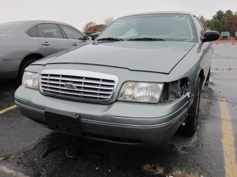 2001 Ford Crown Victoria - Front view of a 2001 Ford Crown Victoria, showing damage to the driver's side headlight.