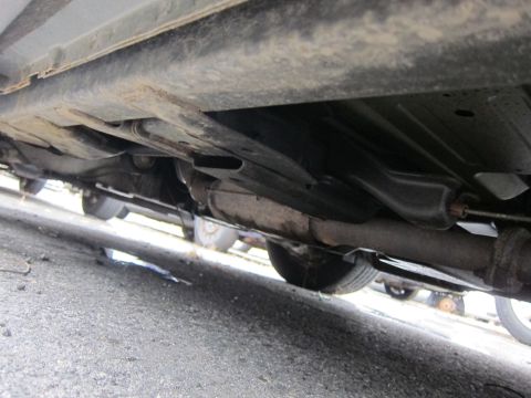 2001 Ford Crown Victoria - The undercarriage of a vehicle is visible, with focus on the exhaust pipe and suspension parts.