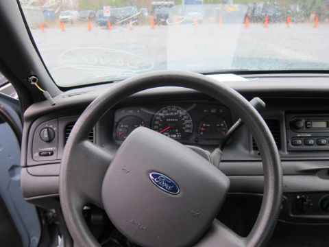 2001 Ford Crown Victoria - The interior of a 2001 Ford Crown Victoria is visible, including the steering wheel and dashboard.