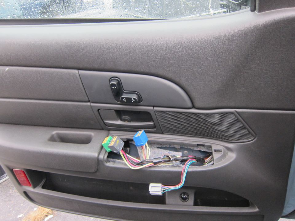 Car door interior with exposed wiring and seat controls
