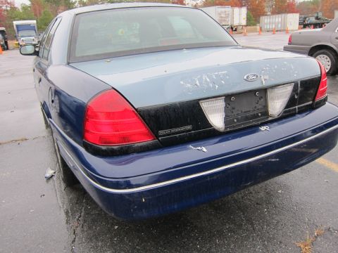 2001 Ford Crown Victoria - Rear view of a 2001 Ford Crown Victoria Police Interceptor, with another vehicle visible in the background.