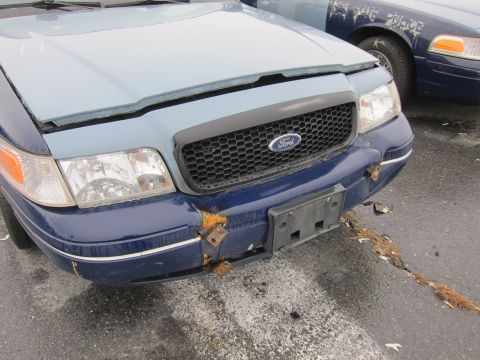 2001 Ford Crown Victoria - Front view of a damaged Ford Crown Victoria, with another similar vehicle visible behind it.