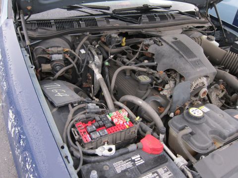 2001 Ford Crown Victoria - The engine compartment of a 2001 Ford Crown Victoria, with the hood open, revealing the engine and associated components.