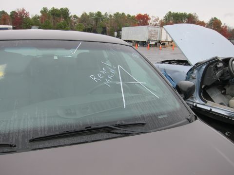 2001 Ford Crown Victoria - Two vehicles are visible, one with chalk markings on its windshield and the other with its hood open.