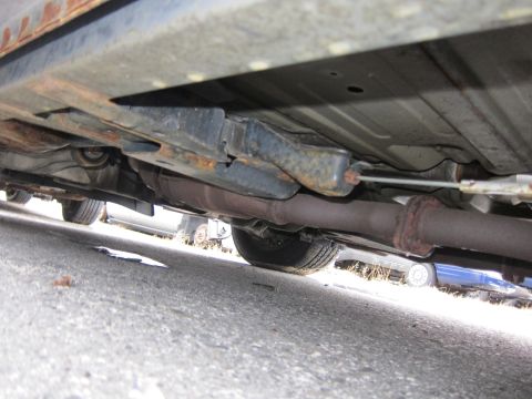 2001 Ford Crown Victoria - The underside of a vehicle, revealing its exhaust system and suspension components with visible signs of rust.