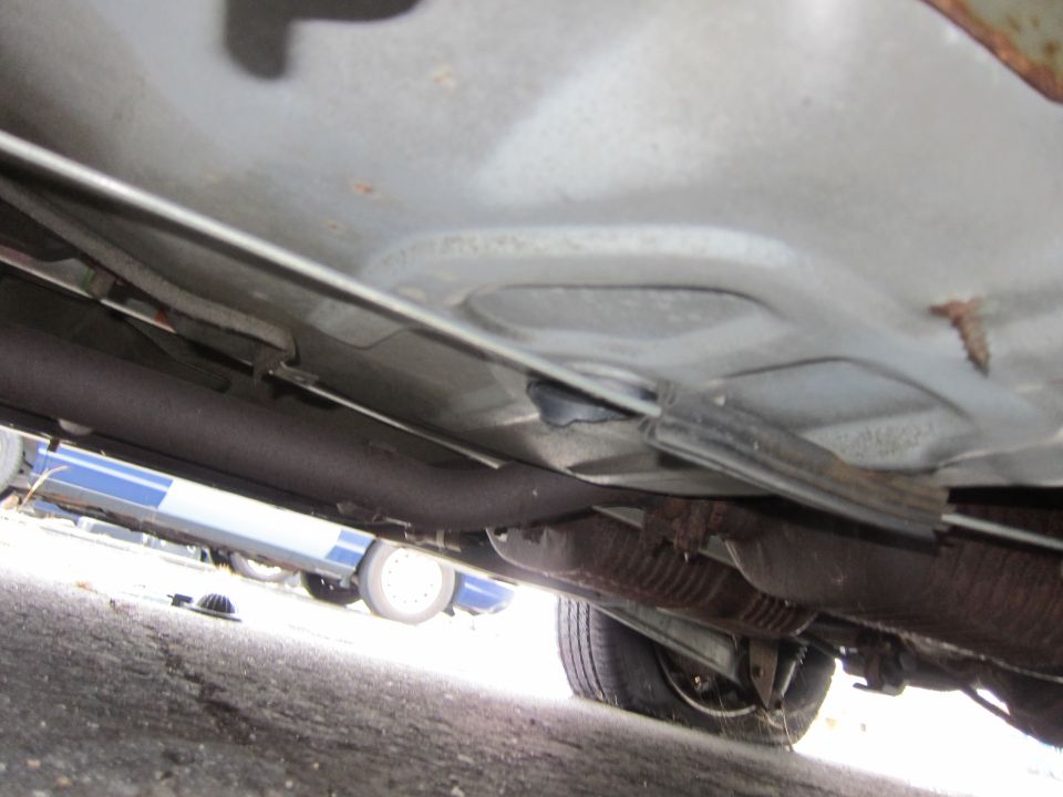 Underside view of a vehicle showing exhaust system and frame components