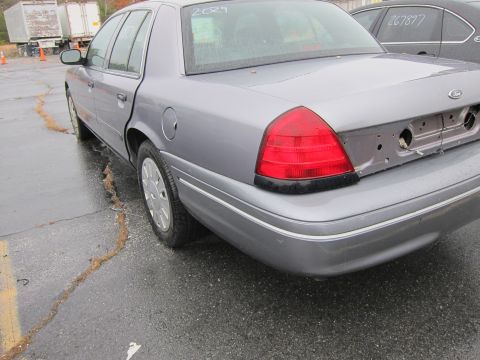 2001 Ford Crown Victoria - Rear view of a silver 2001 Ford Crown Victoria, showing its taillight and missing license plate mounting area.