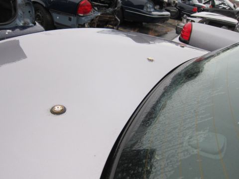 2001 Ford Crown Victoria - Junkyard scene with multiple vehicles, focusing on a car's roof and antennas.