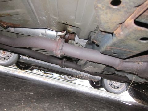 2001 Ford Crown Victoria - Underside view of a car's exhaust system, with multiple vehicles in the background.