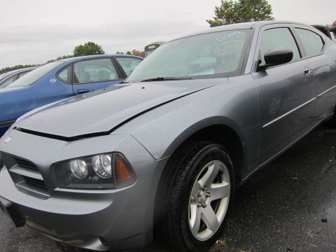 2001 Ford Crown Victoria - A gray Dodge Charger is parked in an outdoor lot with a blue sedan behind it.