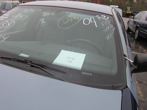 2001 Ford Crown Victoria - A car's windshield has handwritten notes and an item tag, with other vehicles visible in the background.