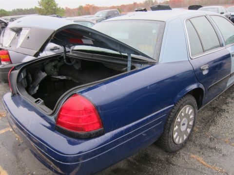 2001 Ford Crown Victoria - Rear view of a blue 2001 Ford Crown Victoria sedan with its trunk open.