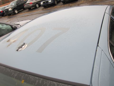 2001 Ford Crown Victoria - A light blue car roof shows large white numbers 07 and a chrome emblem, with other vehicles in the background.