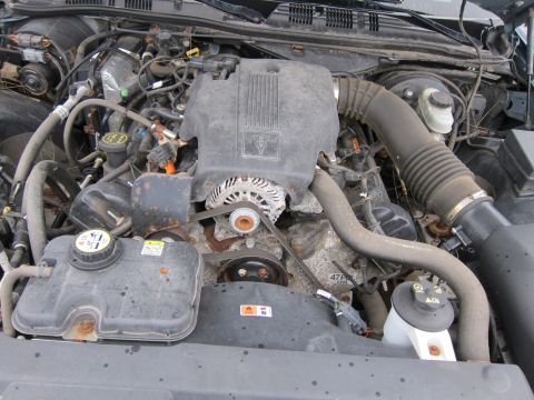 2001 Ford Crown Victoria - Close-up view of a vehicle's engine bay, showing various components like the alternator and air intake system.