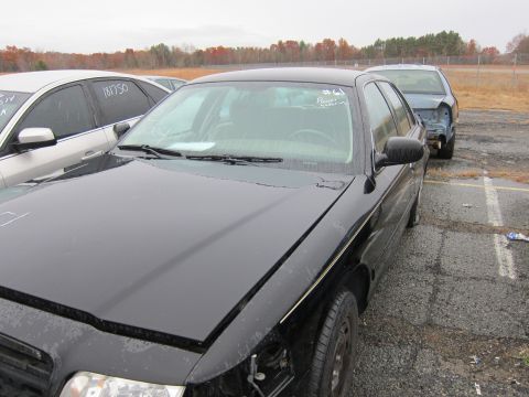 2001 Ford Crown Victoria - A black 2001 Ford Crown Victoria is seen from a three-quarter front angle in a vehicle lot.