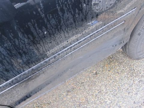 2001 Ford Crown Victoria - Close-up of a car's side panel and tire, showing water damage and wear.