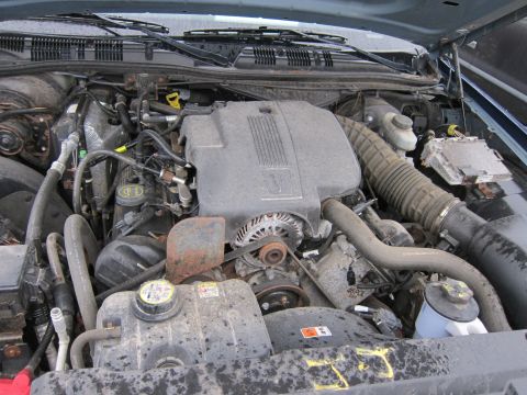 2001 Ford Crown Victoria - The engine bay of a vehicle, showing the V8 engine, various hoses, and the air intake system.