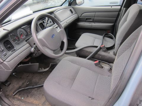 2001 Ford Crown Victoria - The interior of a 2001 Ford Crown Victoria, viewed from the passenger side, reveals the dashboard and front seating area.