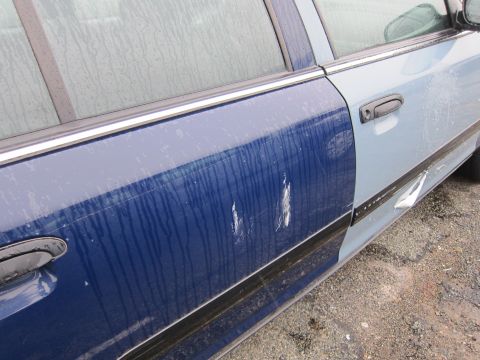 2001 Ford Crown Victoria - Side view of a car door with visible damage and water streaks.