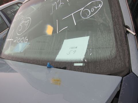 2001 Ford Crown Victoria - Chalk markings and a tag are visible on the windshield of a vehicle in a lot.
