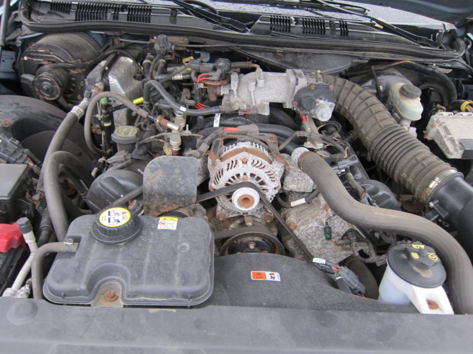 2001 Ford Crown Victoria engine bay with alternator, coolant reservoir, and air intake hose