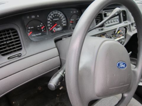 2001 Ford Crown Victoria - The interior of a 2001 Ford Crown Victoria, the steering wheel with the Ford emblem and the instrument cluster.
