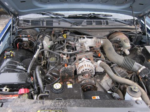 2001 Ford Crown Victoria - The engine bay of a car is shown with the hood open, revealing the motor and associated components.
