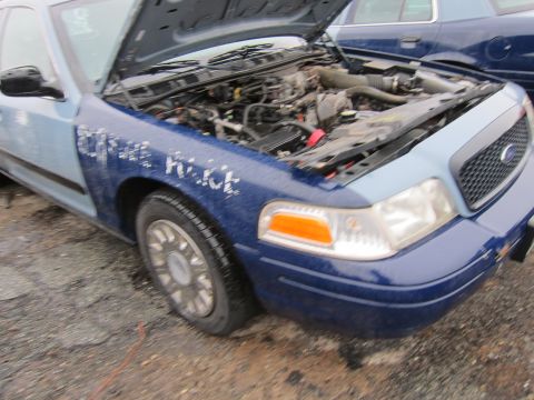 2001 Ford Crown Victoria - A blue and light blue Ford Crown Victoria Police Interceptor is shown with its hood open, revealing the engine compartment.