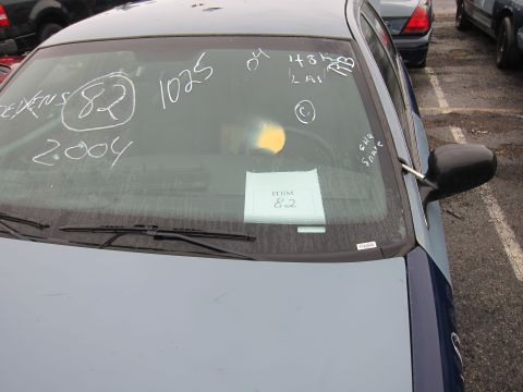 2001 Ford Crown Victoria - Chalk markings on a car's windshield indicate the year 2004 and item number 82.