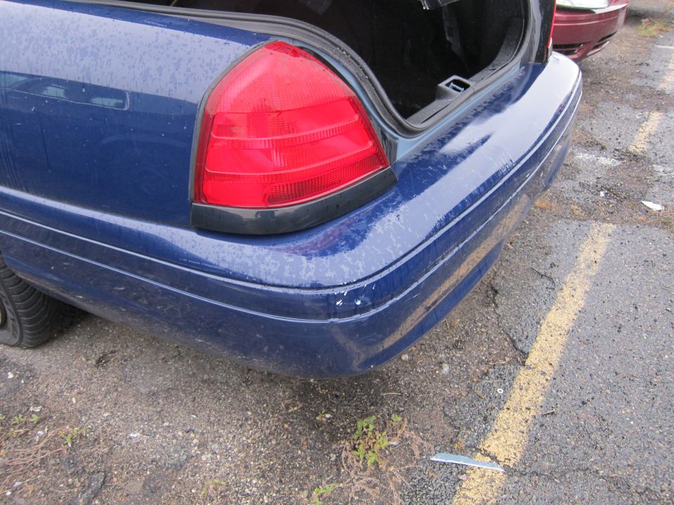 Blue 2001 Ford Crown Victoria rear bumper and taillight, open trunk, parked on asphalt