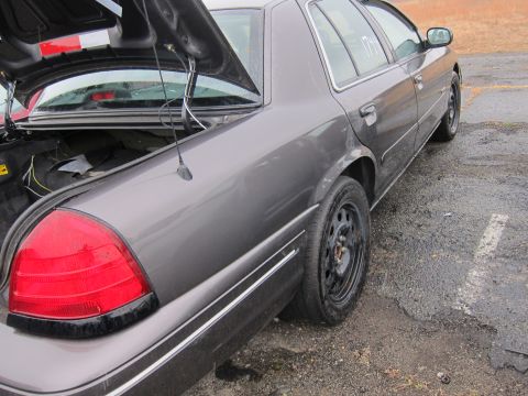2001 Ford Crown Victoria - Rear view of a 2001 Ford Crown Victoria with the trunk open, showing the taillight and antenna.