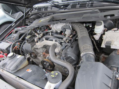 2001 Ford Crown Victoria - The engine bay of a vehicle is shown with various hoses, the air intake, and other engine components.
