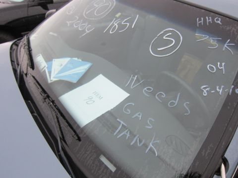 2001 Ford Crown Victoria - Writing on a car's windshield indicates it needs a gas tank and has other service notes.