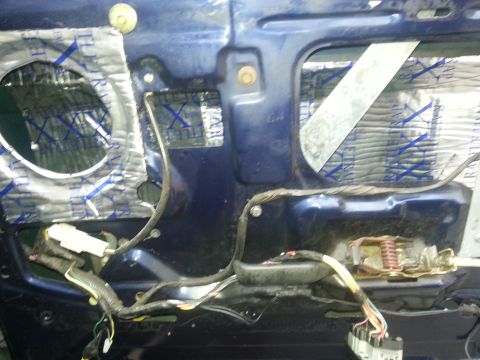 1994 Ford Bronco - The inner workings of a car door are exposed, showing wires and insulation.