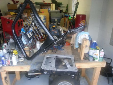1994 Ford Bronco - Car door frame and parts are on a workbench, possibly for restoration or repair.