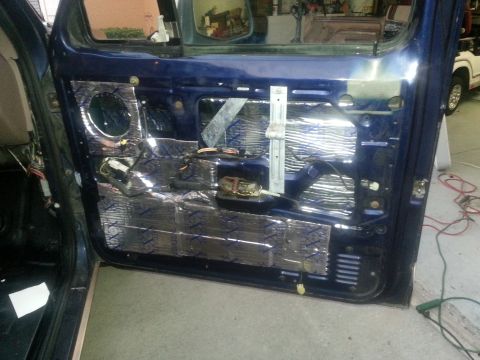 1994 Ford Bronco - The interior of a blue vehicle's door is shown with sound deadening material installed.