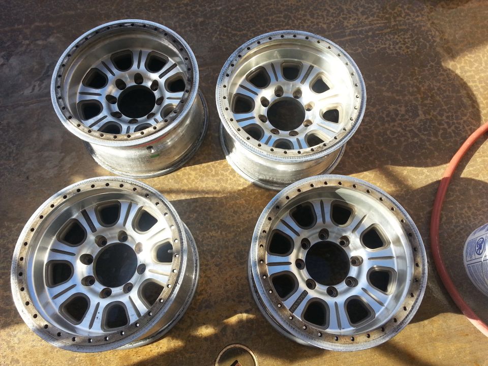 Four aluminum alloy wheels with a multi-spoke design and beadlock rings, seen from above