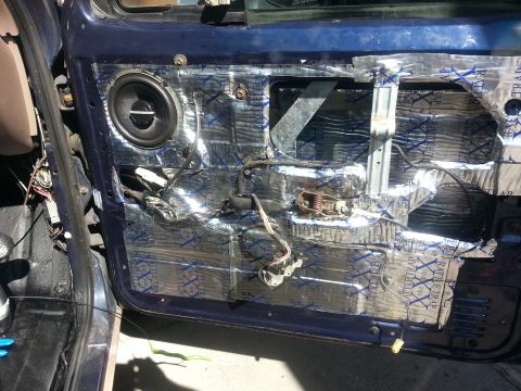 1994 Ford Bronco - Interior view of a car door with sound deadening material and speaker installed.