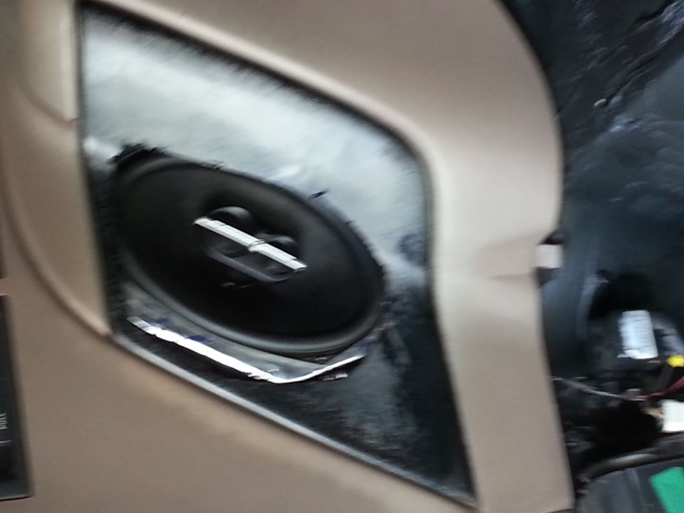 Close-up of a car door speaker grille and mounting area