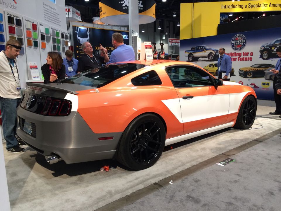 Custom orange and white Ford Mustang on display at a show