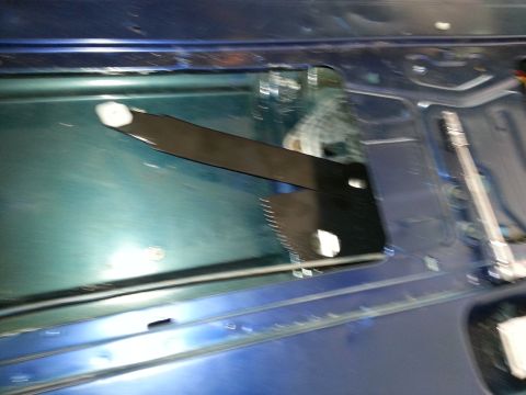 1994 Ford Bronco - Blurry photograph inside a vehicle door showing the window and regulator, not a technical document.
