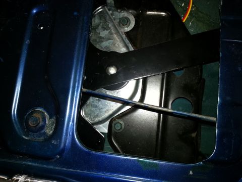 1994 Ford Bronco - Photograph of a door regulator linkage inside a body panel, not a technical document.