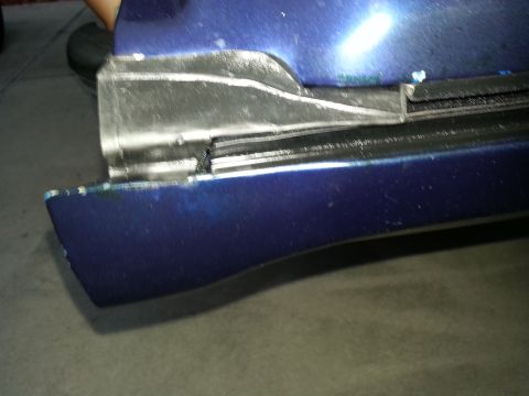 1994 Ford Bronco - Photograph of a blue body panel with a welded metal repair, not a technical document.