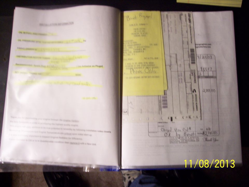 Open binder with handwritten notes and receipts, yellow sticky note attached.