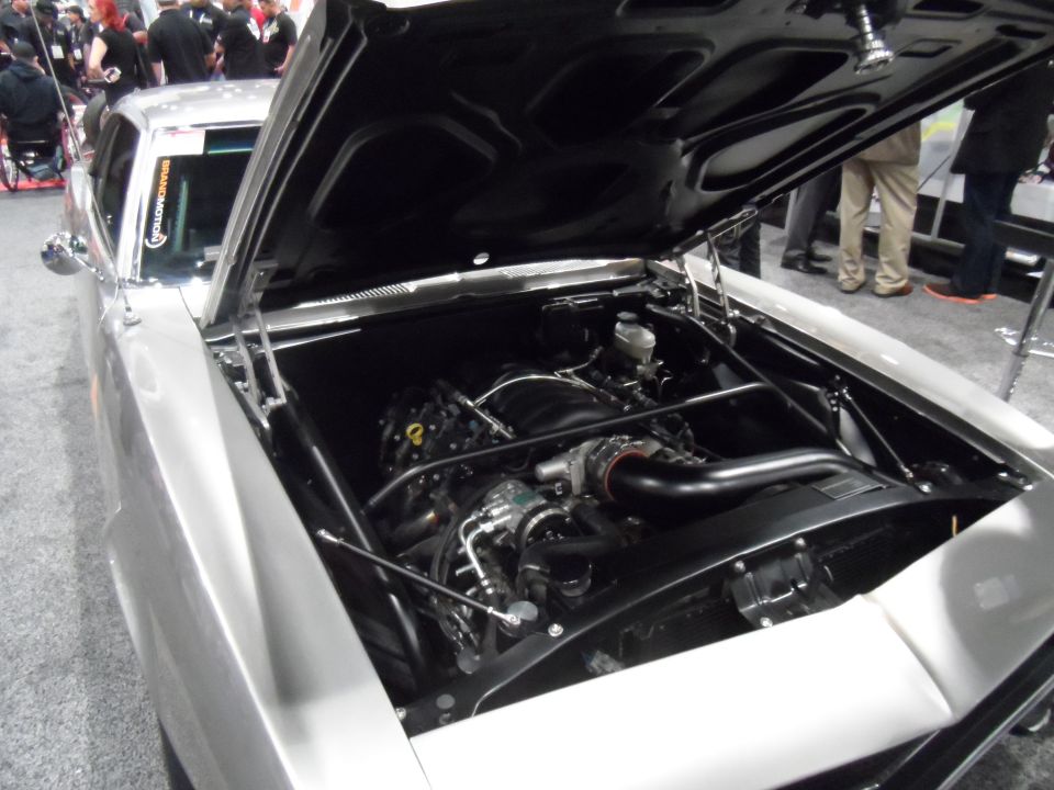 Silver classic car with hood open showing V8 engine with black intake.