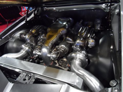 1971 Ford Ranchero - A highly customized, twin-turbocharged V8 engine is showcased in the engine bay of a classic vehicle. The polished chrome and stainless ste…