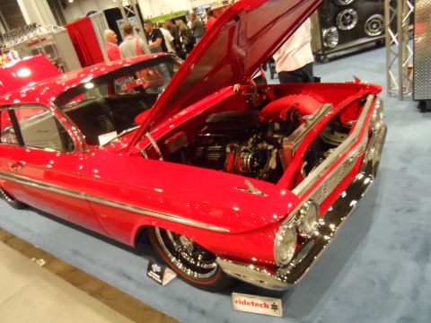 1971 Ford Ranchero - A bright red classic car with its hood open is displayed indoors on a blue carpet. The car features chrome accents and a detailed engine is…